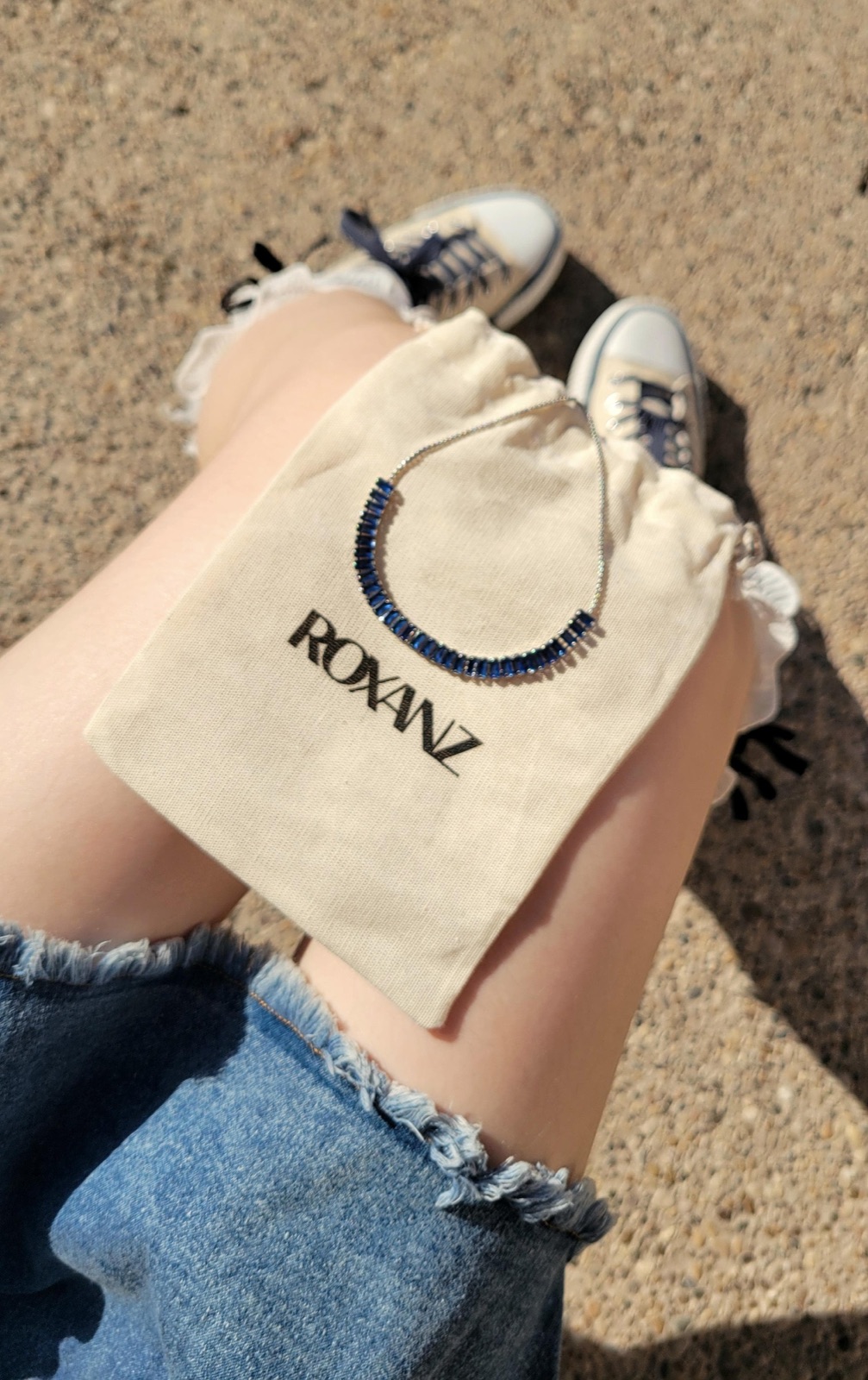 Collar de zafiros ROXANZ sobre su bolsa de tela — contenido entregado